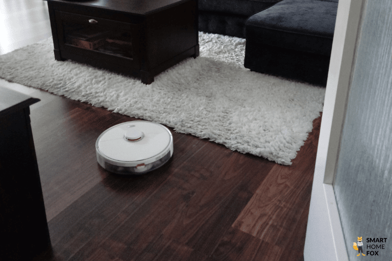 Ein Saugroboter reinigt in einer Wohnung den Boden.